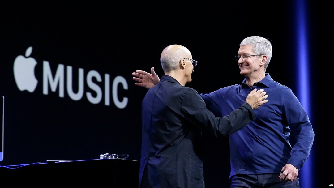 CEO Apple Tim Cook (kanan) merangkul salah satu pendiri Beats by Dre dan pegawai Apple, produser musik Jimmy Iovine dalam sebuah konferensi Apple di San Francisco, Juni 2015. (AP/Jeff Chiu)