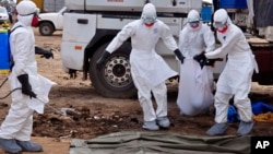 Petugas kesehatan membawa mayat yang ditemukan di jalan yang diduga meninggal akibat virus ebola di Monrovia, Liberia, 12/8/2014. 