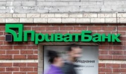 FILE - People walk past a branch of PrivatBank, the country's biggest lender, in Kyiv, Ukraine, April 18, 2019.