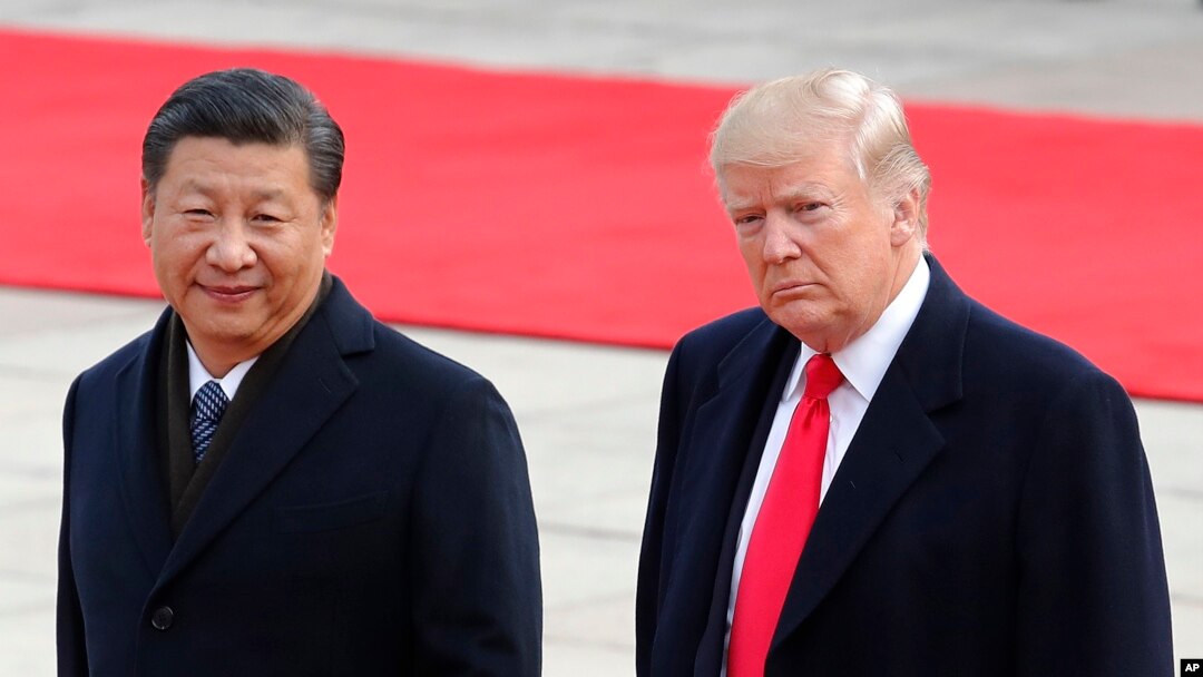 FILE - U.S. President Donald Trump, right, walks with Chinese President Xi Jinping during a welcome ceremony at the Great Hall of the people in Beijing, Nov. 9, 2017. 