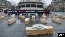 Members of Reporters Without Borders protest with 19 open caskets symbolizing the 19 Ukrainian journalists imprisoned in Russia and a closed one for Ukrainian journalist Victoria Roshchyna, who died in Russian detention, in Paris on Feb. 20, 2025.