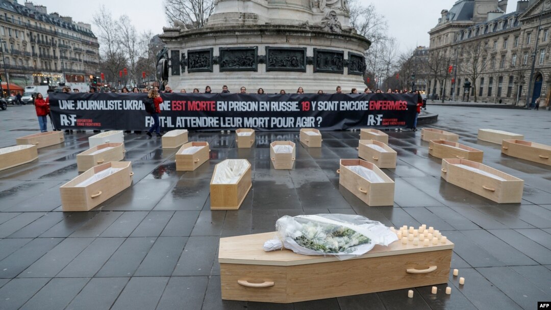 ARCHIVO - Miembros de Reporteros sin Fronteras protestan con 19 ataúdes abiertos que simbolizan a los 19 periodistas ucranianos encarcelados en Rusia y uno cerrado por la fallecida periodista ucraniana Victoria Roshchyna, en París el 20 de febrero de 2025.