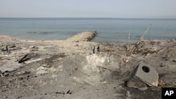 Palestinian boys survey the damage after an Israeli air strike in a resort in Gaza city, April 16, 2011