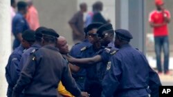 In this Thursday, Sept. 1, 2011 photo, an unidentified journalist from an opposition television station is detained and roughed up by police while covering an opposition protest in Kinshasa, Congo. Minutes after this picture was taken, the photographer wh