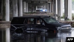An abandoned car sits submerged in floodwaters near the Fort Lauderdale-Hollywood International Airport in Fort Lauderdale, Florida, on June 13, 2024, after heavy rainfall hit the area.