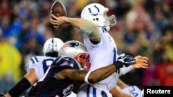 El quarteback de los Colts de Indianápólis, Andrew Luck, lanzará el ovoide pese a ser atrapado por Jamie Collins de los Patriotas de Nueva Inglaterra. [Foto: Andrew Weber-USA TODAY Sports].