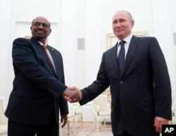 FILE - Russian President Vladimir Putin, right, shakes hands with Sudan's President Omar al-Bashir during their meeting in the Kremlin in Moscow, Russia, Saturday, July 14, 2018.