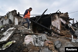 Seorang sukarelawan memeriksa sisa-sisa rumah penduduk yang rusak akibat serangan rudal Rusia di Zaporizhzhia, Ukraina 9 April 2023. (Foto: Reuters)