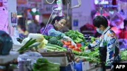 2021年11月1日，中国广西南宁某菜市场一位顾客在购买蔬菜。