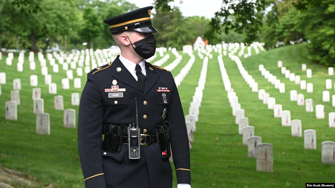 Seorang tentara AS berdiri di depan jajaran makam dari tentara AS yang tak dikenal yang meninggal dalam beberapa perang seperti Perang Dunia I dan II serta Perang Vietnam, dalam sebuah acara di kompleks pemakaman di Arlington, Virginia pada 25 Mei 2020. (Foto: Reuters/Erin Scott 