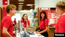 Teenagers work inside a branch of Vodafone mobile communication provider, amid Russia's attack on Ukraine, in Kyiv, Ukraine, Aug. 14, 2024