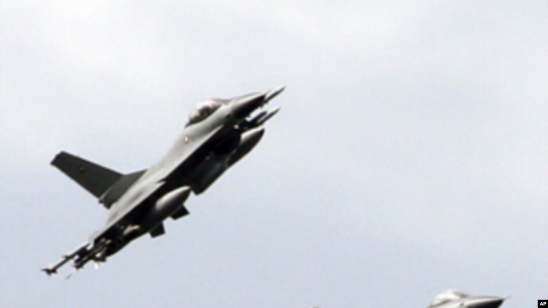 Two Danish F-16 jet fighters prepare to land at the Nato airbase in Sigonella, Italy, Monday, March 21, 2011. (AP Photo/Andrew Medichini)