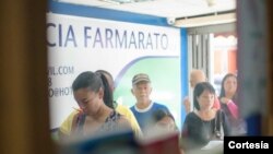 Personas hacen fila para comprar medicina en Farmarato, farmacia en el corazón de un populoso barrio al oeste de Caracas, Venezuela. Foto: Camilo Paparoni.