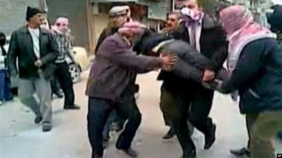 In this still image taken from video protesters in a Damascus suburb purportedly carry a wounded comrade Friday, December 30, 2011. Image content not independently verifiable.