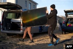 Residents carry belongings from their homes to a vehicle in Grindavik, Iceland, on Nov. 13, 2023, following earthquakes that led authorities to call an evacuation of the town of about 4,000.