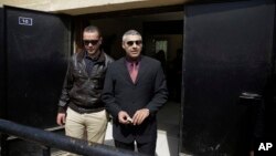 Al-Jazeera English journalists Canadian Mohamed Fahmy, right, and Egyptian Baher Mohammed leave a court after a hearing in their retrial near Tora prison in Cairo, Egypt, March 8, 2015. 