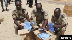 Burkinabe soldiers, part of the MISMA African forces in Mali, receive blue berets to signify the change of mission command to the UN in Timbuktu, June 30, 2013. 