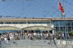 FILE - Turkish soldiers stand outside the court in a prison complex where the trial of prominent philanthropist Osman Kavala and 15 others started, while people arrive, in Silivri, outside Istanbul, June 24, 2019.