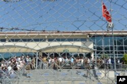 FILE - Turkish soldiers stand outside the court in a prison complex where the trial of prominent philanthropist Osman Kavala and 15 others started, while people arrive, in Silivri, outside Istanbul, June 24, 2019.