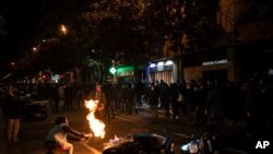 Seorang demonstran membakar sepeda motor dalam unjuk rasa memprotes penahanan penyanyi rap Pablo Hasél di Barcelona, Spanyol, Sabtu, 20 Februari 2021. 