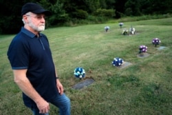 Eddie Davis stands beside the gravestone of his son Jeremy, furthest left, who died from the abuse of opioids at the age of 35, July 17, 2019, in Coalton, Ohio.
