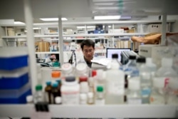 FILE - A research scientist works in a laboratory at Vertex Pharmaceuticals Inc. in San Diego, March 4, 2015.