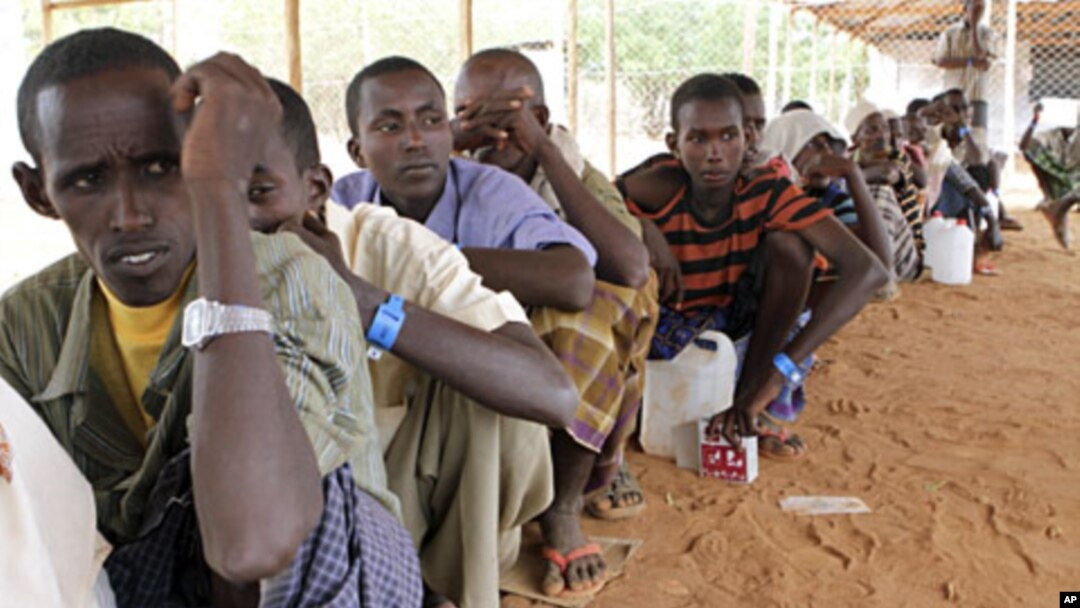Newly arrived Somali refugees queue for relief food at the Dadaab refugee camp, near the Kenya-Somalia, July 23, 2011