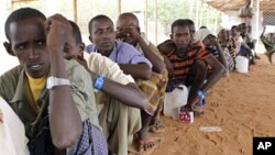 Newly arrived Somali refugees queue for relief food at the Dadaab refugee camp, near the Kenya-Somalia, July 23, 2011