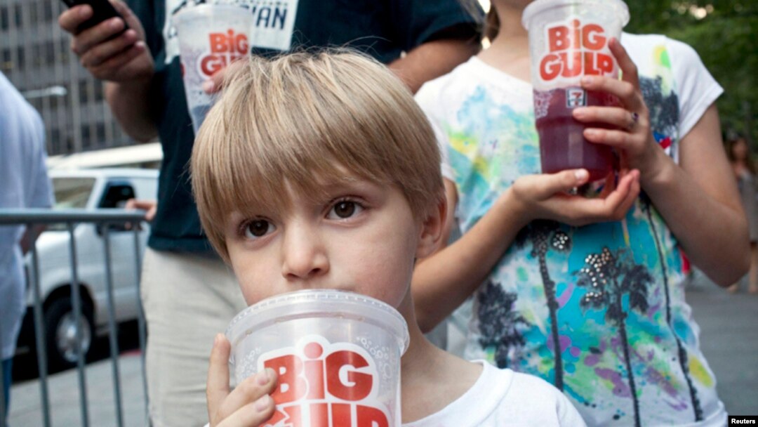 Benjamin, 8, minum soda berukuran besar saat ikut serta dengan ayahnya dalam protes terhadap larangan penjualan soda berukuran besar di New York. (Foto: Dok)