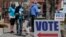 FILE - Electioneers greet voters outside the Hamilton County Government Center during early voting in Noblesville, Indiana, April 27, 2018