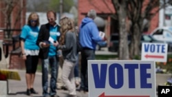 FILE - Electioneers greet voters outside the Hamilton County Government Center during early voting in Noblesville, Indiana, April 27, 2018.