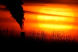 Emissions from a coal-fired power plant are silhouetted in Independence, Missouri, Feb. 1, 2021.