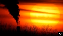 FILE - Emissions from a coal-fired power plant are silhouetted in Independence, Mo., Feb. 1, 2021. A U.N. report released Feb. 18 says humans are making Earth an increasingly unlivable planet through climate change, biodiversity loss and pollution.