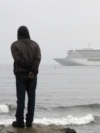 A man stands on the shores of the Bering Sea to watch the luxury cruise ship Crystal Serenity, anchored just outside Nome, Alaska, because it was too big to dock at the Port of Nome, Aug. 21, 2016.