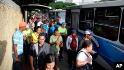 Para calon penumpang berdiri di jalur bus di Caracas, Venezuela, Selasa, 23 Juli 2019. Lampu kembali menyala di seluruh Venezuela Selasa pagi (23/7), menyusul pemadaman besar sehari sebelumnya yang melumpuhkan komunikasi di kota Caracas.