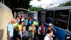 People stand in a bus line in Caracas, Venezuela, July 23, 2019. 