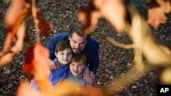 Christopher Hughey poses for a picture with his sons, Henry, 5, Harrison, 9, Nov. 21, 2020, in Charlotte, N.C. Food experts say Americans nervous about making their first Thanksgiving meals can follow a few basic tips to avoid disaster.