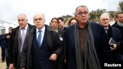 Le ministre grec Yannis Mouzalas escorte le ministre français Bernard Cazeneuve lors de sa visite dans un centre d'enregistrement sur l'île de Lesbos le 4 février 2016.