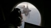 FILE - Flight officer Rayan Gharazeddine scans the water in the southern Indian Ocean off Australia from a Royal Australian Air Force AP-3C Orion during a search for the missing Malaysia Airlines Flight MH370, March 22, 2014. 