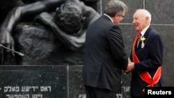 Poland's President Bronislaw Komorowski decorates Simcha Rotem with the Grand Cross of the Order of the Rebirth of Poland during a ceremony commemorating the 70th anniversary of the Warsaw Ghetto Uprising at the Monument to the Ghetto Heroes, in Warsaw, April 19, 2013.