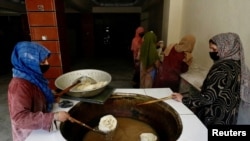 Sejumlah perempuan Afghanistan tampak menggoreng kue trasional di sebuah toko kue di Kabul, Afghanistan, pada 5 Mei 2024. (Foto: Reuters/Sayed Hassib)