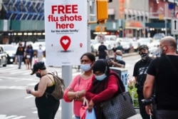 FILE - An ad offering free flu shots is seen in Brooklyn, New York, Aug. 21, 2020.