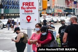 FILE - An ad offering free flu shots is seen in Brooklyn, New York, Aug. 21, 2020.