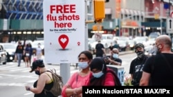 FILE - An ad offering free flu shots is seen in Brooklyn, New York, Aug. 21, 2020.