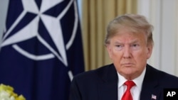 U.S. President Donald Trump grimaces during a meeting with NATO Secretary General, Jens Stoltenberg at Winfield House in London, Tuesday, Dec. 3, 2019.