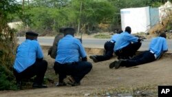 FILE - Kenyan police take cover outside Garissa University College during an attack in Garissa, Kenya, April 2, 2015. Dulyladeyn, the al-Shabab terrorist sought for his role in planning the attack, was killed in an assault this month. 