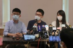 Activistas prodemocracia, de izquierda; Joshua Wong, Nathan Law y Agnes Chow asisten a una conferencia de prensa en Hong Kong, el sábado 30 de mayo de 2020.