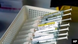 FILE - Syringes containing the Pfizer-BioNTech COVID-19 vaccine sit in a tray in a vaccination room at St. Joseph Hospital in Orange, Calif., Jan. 7, 2021.