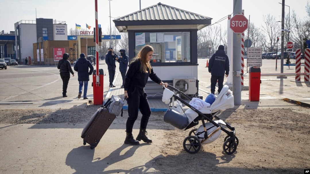 Бегалка која избегала од конфликтот од соседна Украина турка количка за бебе откако ја преминала молдавско-украинската граница, во Паланка, Молдавија, сабота, 26 февруари 2022 година