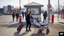 Ukrajinska izbjeglica sa bebom u kolicima nakon prelaska ukrajinsko-moldavske granice, nedugo nakon početka ruske invazije, 26. februara 2022. godine. (Foto: AP/Aurel Obreja)